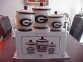 Picture: Georgia Bulldogs 3-Piece Canister Set in mint condition. Never used and still in original factory box! The largest Canister is 7 inches high and 22 inches around. The middle Canister is 5.5 inches tall and 19 inches around. The smallest Canister is 5 inches tall and 16 inches around.