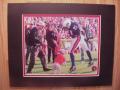 Picture: UGA V Barks at Auburn's Robert Baker original "Victory on the Plains" 8 X 10 photo professionally double matted to 11 X 14 to fit a standard frame. This is the most popular college photo of all-time and helped earn UGA the cover of Sports Illustrated as the nation's number one mascot. You know this is an original photo and not one of the many "fakes" on the market because you can see the photographer with the hat in the background. If you do not see this person in this photo, it is not authentic!