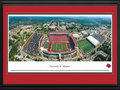 Picture: Arkansas Razorbacks Donald W. Reynolds Razorback Stadium panoramic poster professionally double matted in team colors and framed. This aerial panorama of the University of Arkansas was taken by James Blakeway during an Arkansas Razorback football game. Centered in the panorama is Donald W. Reynolds Razorback Stadium. Originally named Bailey Stadium in 1938, it was renamed Razorback Stadium in 1941. After a $20 million contribution to the 2001 stadium expansion by the Donald W. Reynolds Foundation, capacity increased to 72,000. The University, founded in 1871 in Fayetteville, Arkansas on a hilltop farm overlooking the Ozark Mountains, is home to one of the most beautiful assemblages of collegiate athletic venues in the Southeastern Conference, including Bud Walton Arena, the football practice fields and the John McDonnell Track Field.