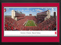 Picture: Nebraska Cornhuskers Memorial Stadium 13 X 40 panoramic print professionally double matted in team colors and framed to 18 X 44. This panorama, taken by Sheila Gjevre, shows a “Sea of Red” as the Nebraska Cornhuskers football team play for another victory in Memorial Stadium. Since 1923, Memorial Stadium has been the home to Huskers football and continues to provide one of the most exciting game day experiences in all of college football. Today, after completion of the East Stadium expansion, the stadium seats over 92,000 fans. Rich with tradition, Husker fans continue to celebrate the first score of every home game with the release of red balloons into the sky. The University of Nebraska-Lincoln, chartered in 1869, was one of the first institutions west of the Mississippi River to award doctoral degrees.