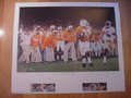 Picture: Al Wilson, Jeff Hall, Head Coach Phil Fulmer, and Peerless Price hand-signed 24 X 28 limited edition "Championship Destiny" print signed and number by the artist in excellent plus shape with no pin holes or tears. The image area of the print is 17 1/4 X 25 1/2. The autographs are absolutely guaranteed authentic and not only come with a Certificate of Authenticity but pictures of each of the four actually signing the print on the COA. Artist Doug Hess captures the key play which clenched the game and the National Championship as the Vols took destiny in their own hands with 23-16 victory over Florida State University. This print preserves this special moment in time capturing the spirit and emotions of the Tennessee sideline as the celebration erupts when Peerless Price snags a perfectly thrown pass and leaves the FSU cornerback behind on his way to the 79-yard touchdown, longest in Fiesta Bowl history. The print features Head Coach Phillip Fulmer, Peerless Price, Al Wilson and Jeff Hall. The print comes with six remarque prints that document key moments during the season which were stepping stones to the 1998 National Championship. It also comes with the original gold embossed seal that can be used in framing to make this piece look even better. There are also hidden images and symbolism in this print.