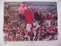 Picture: Georgia Bulldogs "The First 100 Years-1892-Georgia Football Centennial-1992" print signed and numbered by artist Paul Miller. This print features the first football team of 1892, Troy Sadowski, Tim Worley, Wilber Strozier, John Little, Peter Anderson, Jeff Sanchez, Kevin Butler, Freddie Gilbert, Jimmy Payne, Terry Hoage, Herschel Walker, Scott Woerner, Rex Robinson, Bill Krug, George Collins, Allan Leavitt, Ben Zambiasi, Joel Parrish, Mike Wilson, Randy Johnson, Craig Hertwig, Theron "The Drought Breaker" Sapp, Royce Smith, Tommy Lyons, Steve Greer, Jake Scott, Bill Stanfill, Lynn Hughes, Edgar Chandler, George Patton, Ray Rissmiller, Wilbert Strozier, Jim Wilson, Fran Tarkenton, Pat Dye, Johnny Carson, Harry Babcock, John Rauch, Bill Hartman, Vernon "Catfish" Smith, Bob McWhorter, the Dream Backfield of Frankie "Flatfoot" Sinkwich, Charlie Trippi, Richard McPhee, Lamar "Racehorse" Davis, Flea Flicker to beat Alabama, Larry Munson, UGA, Erk Russell, Ray Goff, Vince Dooley, Wally Butts, Harry Mehre, H.J. Stegman, Glen S. "Pop" Warner, and others.