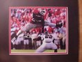 Picture: Knowshon Moreno hand-signed Georgia Bulldogs 8 X 10 photo professionally double matted to 11 X 14 so that it fits a standard frame. The autograph is absolutely guaranteed authentic and comes with a Certificate of Authenticity from GeorgiaBulldogsPrints.com. Moreno signed this "Hurdle" photo in silver paint pen because this type of signature never fades. Additionally, we have seen many fake autographed Moreno photos signed in black sharpie. Black sharpie autographs can be copied to look real while silver paint pen cannot and thus our decision to go with silver paint pen on all Moreno signatures.